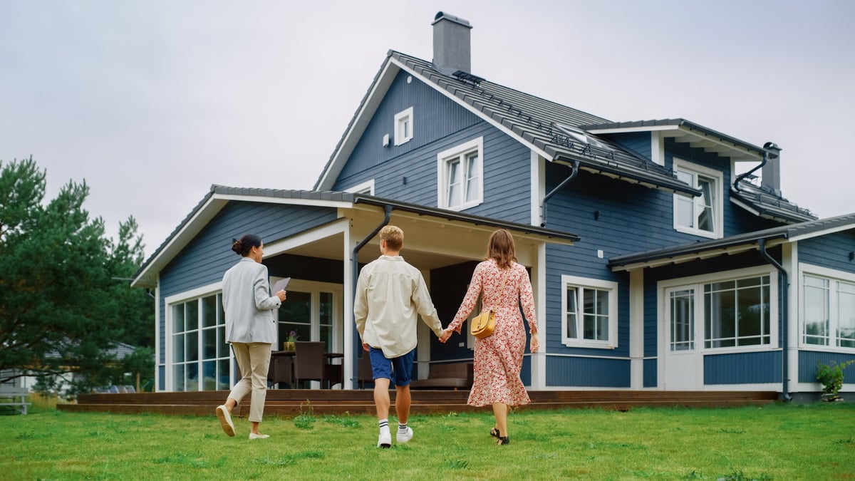 Couple viewing a rental property with a property manager outside the home