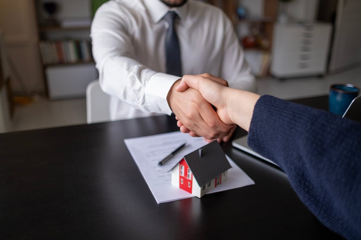 Property manager shaking hands with a client after signing a management agreement